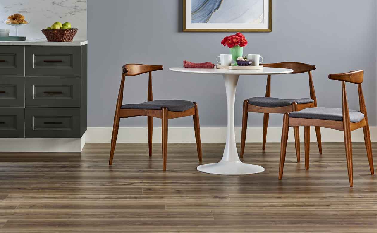 Wood look vinyl flooring in kitchen with white table and wood chairs